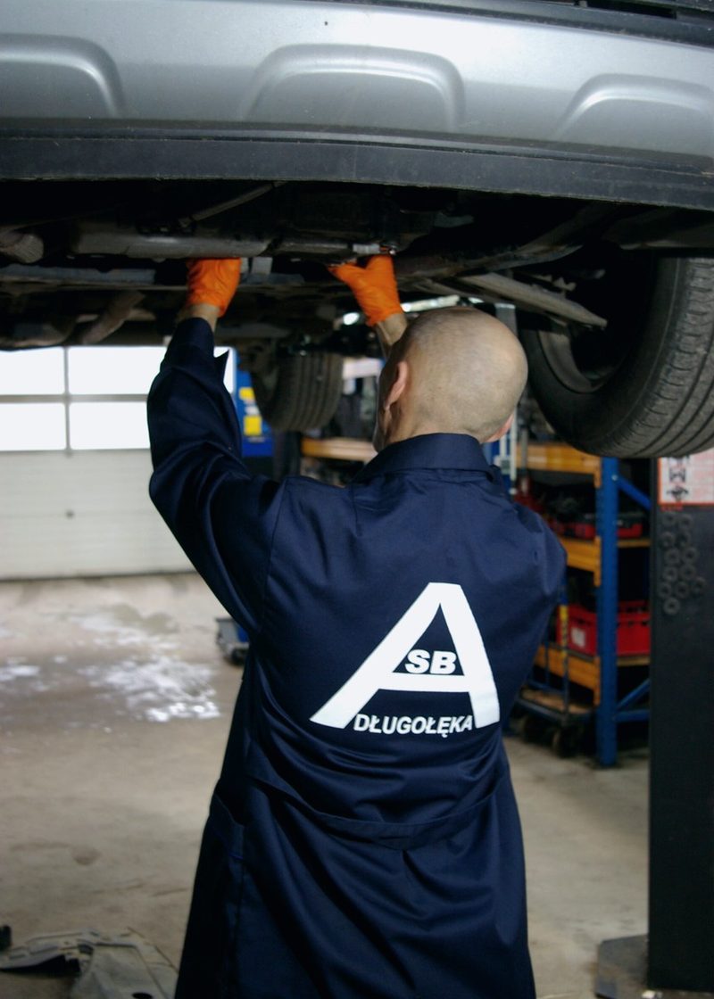 ASB Długołęka mechanic working under a car on a lift